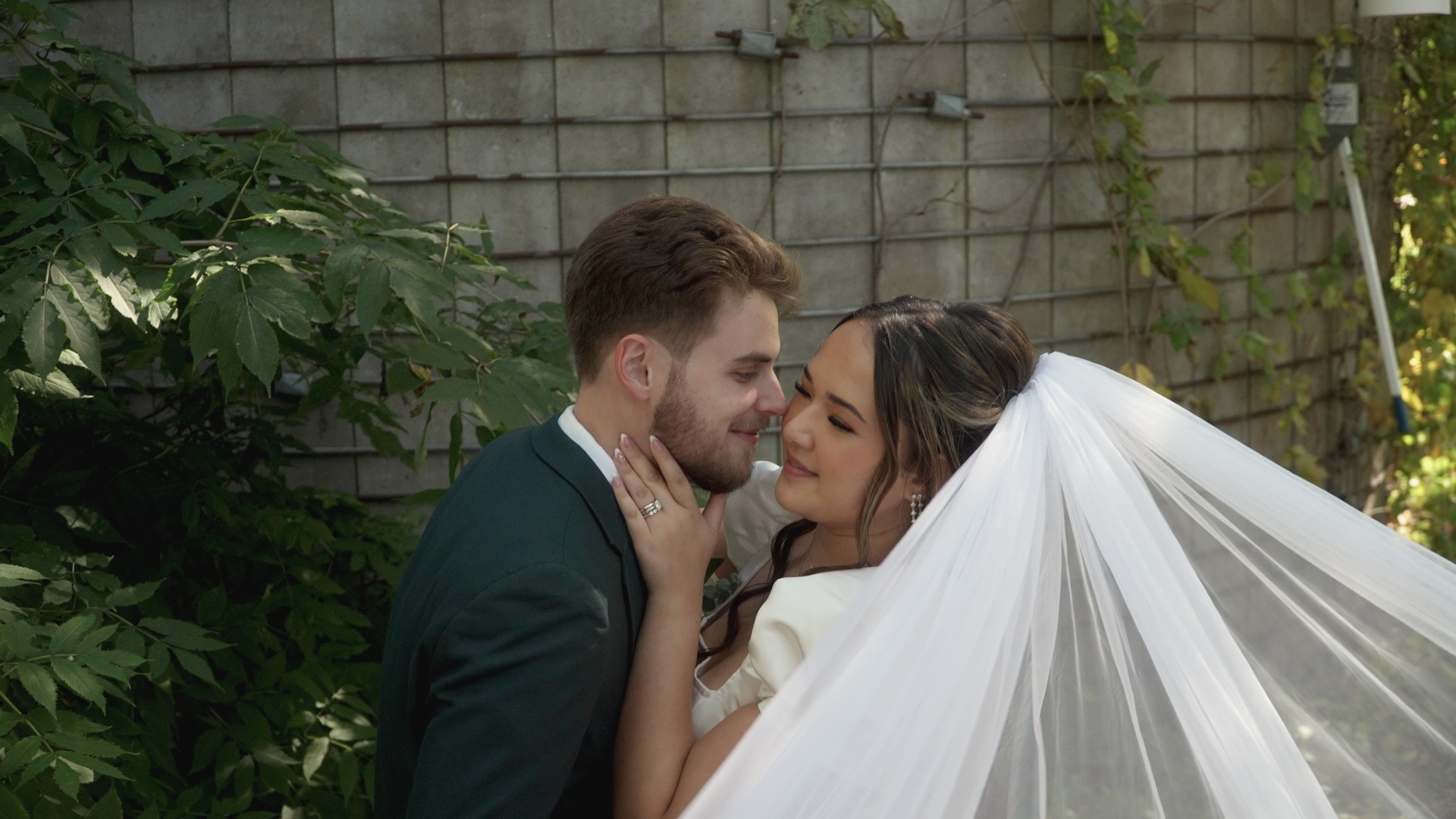 A couple sharing a quiet moment as her veil lifts in the breeze